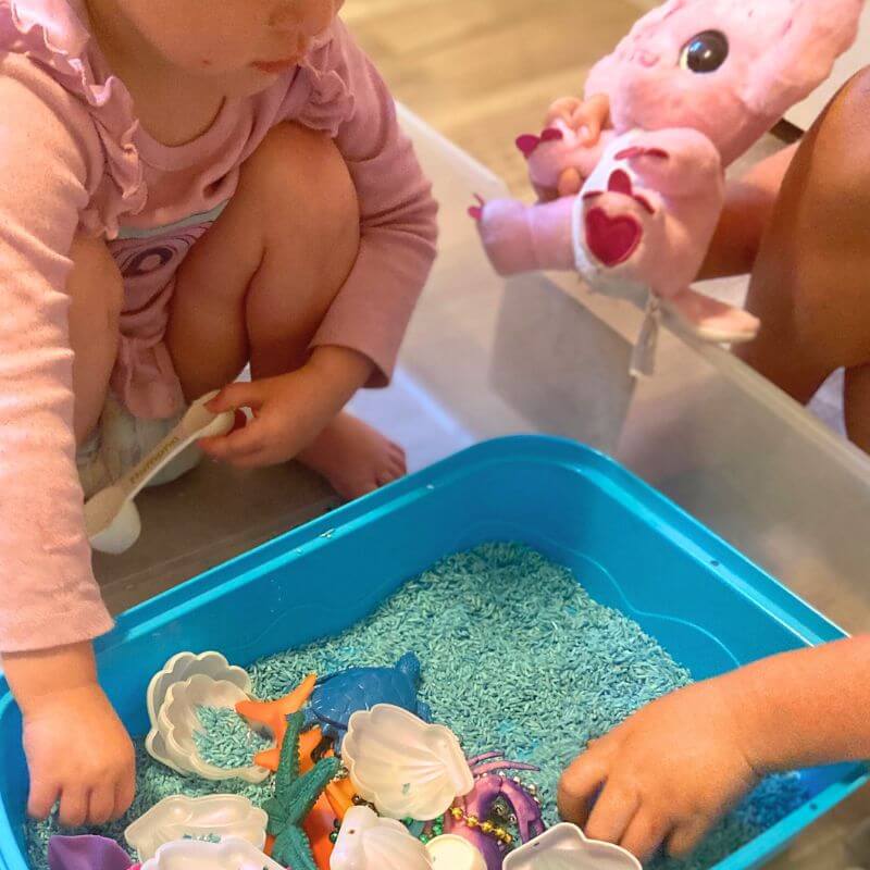 ella and ruthie playing with ocean sensory bin