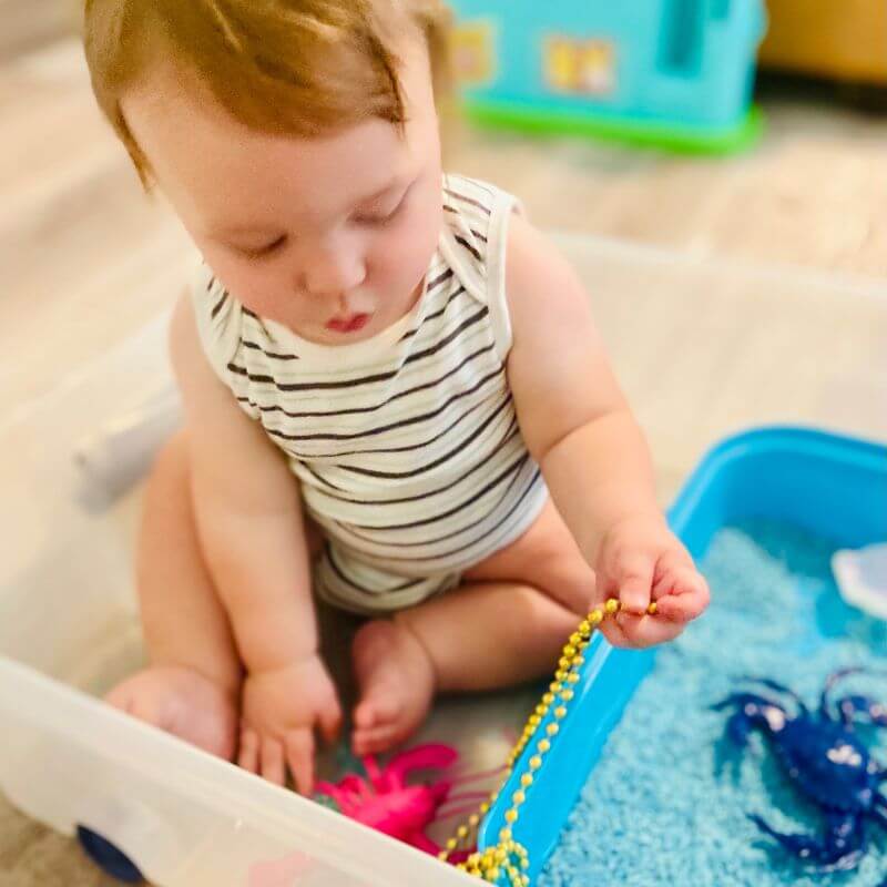 klay playing with ocean sensory bin