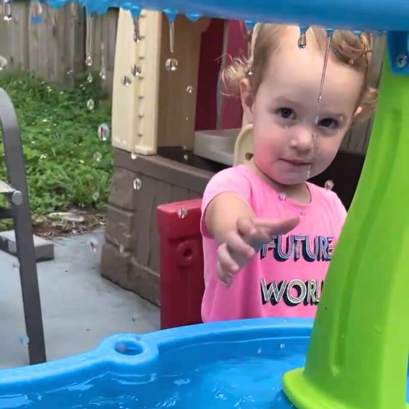 young toddler play at the water table