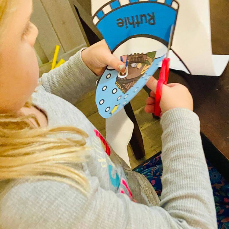 child cutting out snow globe name craft